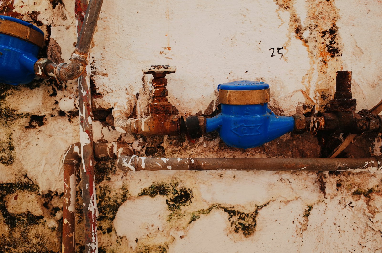 Plumber inspecting pipes under a bathroom sink for hidden leak