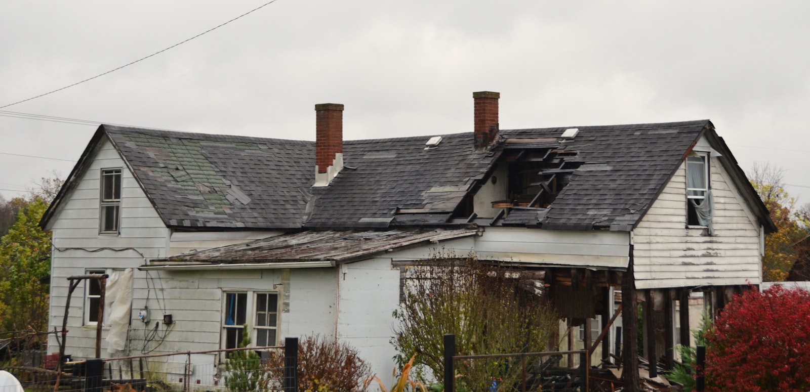 Roof damage on a Hauppauge home — collapsed section and missing shingles before Heritage Roofing repair